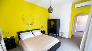 A bedroom with a bed, a nightstand, a lamp, a wardrobe, and a hanging light fixture. - Deluxe Double Room with Shared Terrace, Wi-Fi and Air Conditioning (Vietri sul Mare)