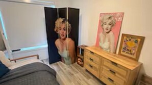 Ein Schlafzimmer mit einem Bett, einem Schminktisch und einem Bild an der Wand.