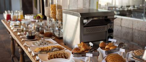 A buffet with various food items and a coffee machine.