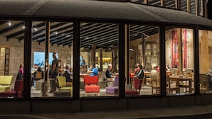 A modern interior with large windows, wooden beams, and a variety of seating arrangements. - Hotel Rosario Uyuni Collection (Uyuni)