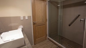 A bathroom with a glass-enclosed shower, a wooden door, and a white bathtub. - Hotel Rosario Uyuni Collection (Uyuni)