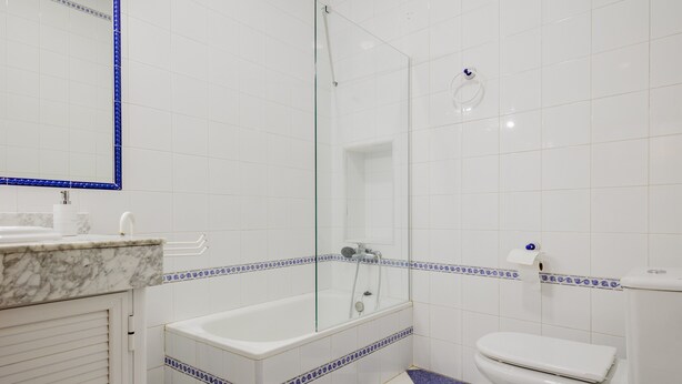 Une salle de bain équipée d’une baignoire, de toilettes et d’une douche à parois en verre.