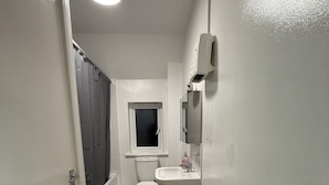 Un baño pequeño y estrecho con inodoro, lavabo y ventana.