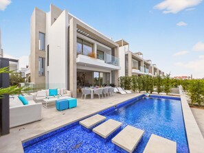 A modern residential building with a swimming pool, outdoor seating, and a balcony. - Azure Jade Villa | Luxury Retreat, Private Pool (Protaras)