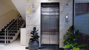 An elevator with a 'LIFT' sign above it, a 'STORE ROOM' sign to the right, and a 'VISITORS NOT ALLOWED' sign above the elevator. - Felix Inn Boutique Hotel - Manyata Tech Park (Bengaluru)