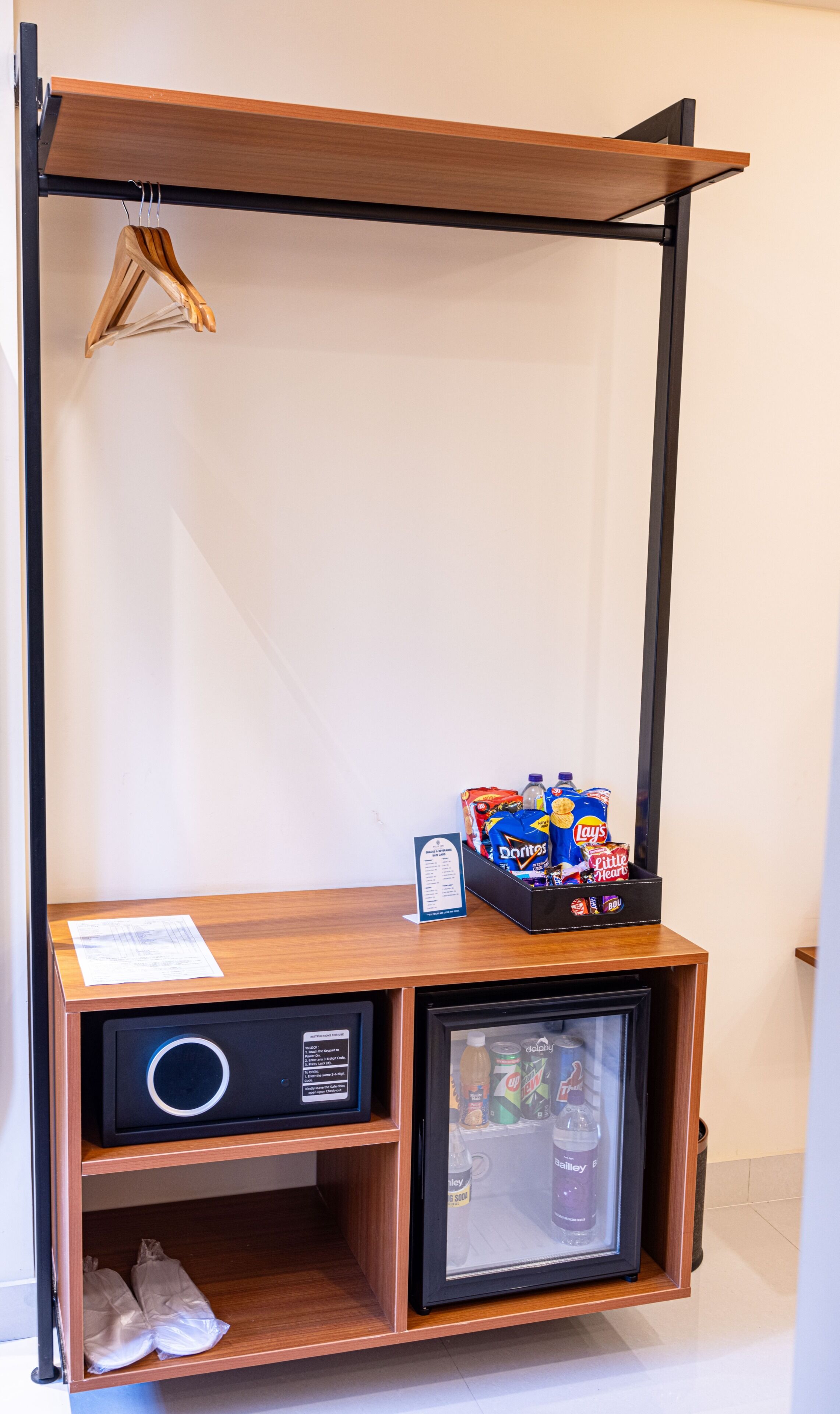 A compact minibar with a beverage cooler, a small refrigerator, and a hanging rack.