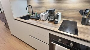 Une cuisine moderne dotée d’un évier encastré, d’une machine à café, d’un grille-pain et d’une plaque de cuisson à induction.