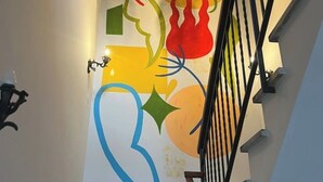 A staircase with a colorful abstract mural on the wall. - Il Torrione - Cozy Independent House for 4, between History and Relaxation (Castel Bolognese)