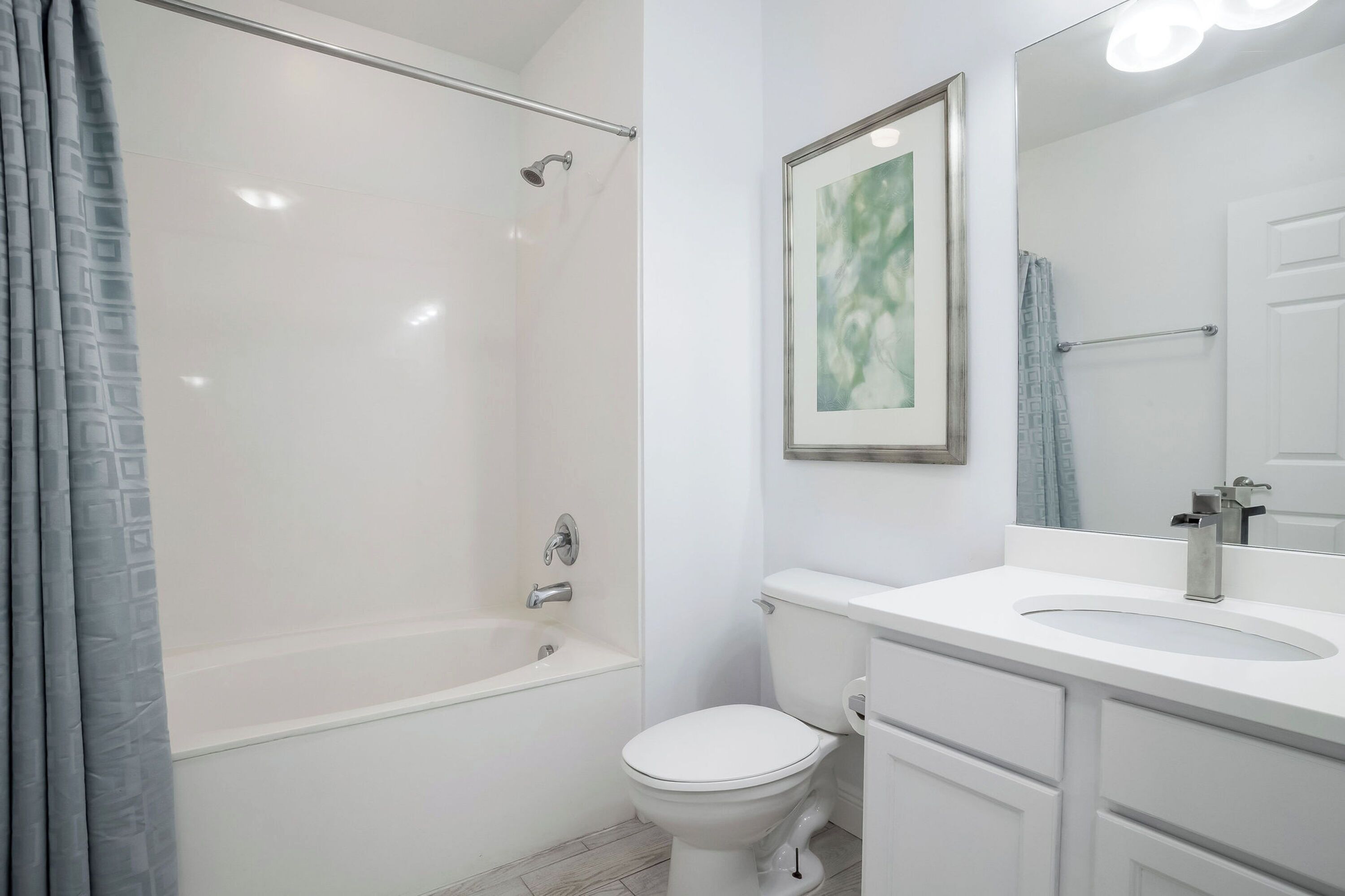 A bathroom with a bathtub, toilet, and sink.