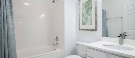 A bathroom with a bathtub, toilet, and sink.