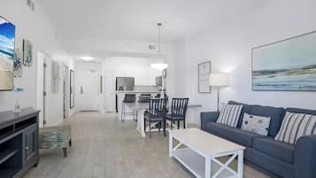 Una sala de estar moderna con un sofá gris, una mesa de centro y un comedor con sillas y una mesa.