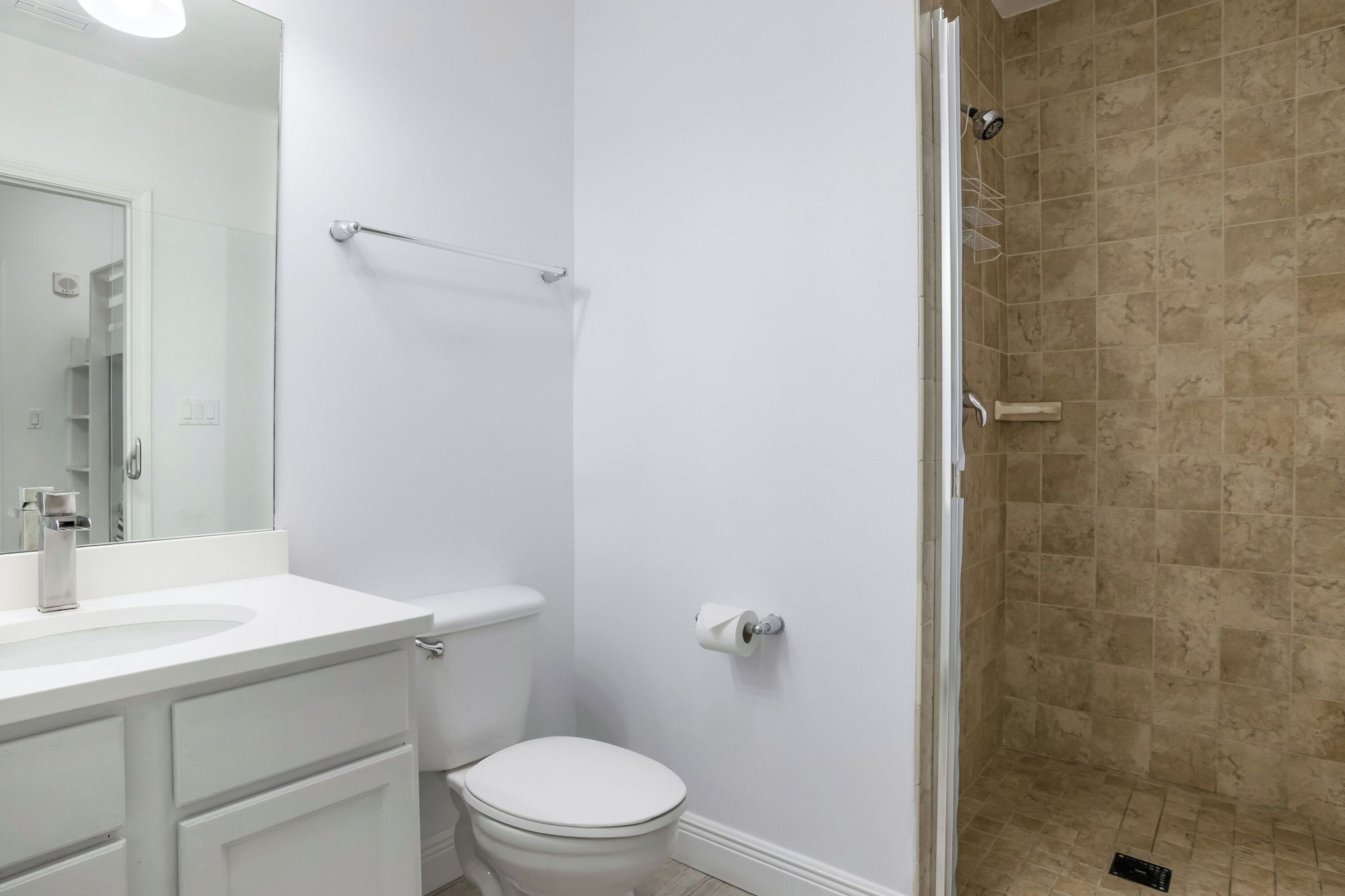 Een badkamer met toilet, wastafel en douche.