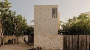 Un edificio moderno con fachada de piedra y una ventana pequeña.