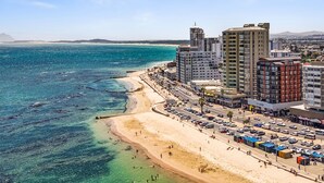 Eine Küstenstadt mit Strand, Hochhäusern und einem klaren, blauen Meer.