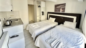 A hotel room with two beds, a kitchenette, and a bathroom. - Royal Pera Taksim (Istanbul)