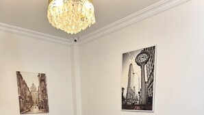 A dining area with a white table, black upholstered chairs, a black sofa, and a chandelier. - Royal Pera Taksim (Istanbul)