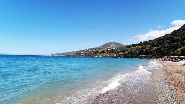 A beach with clear blue water, pebbly shore, and a mountain in the background. - Casa Calma Country Villa Escape with Private Pool (kato Pteri, Diakopto)