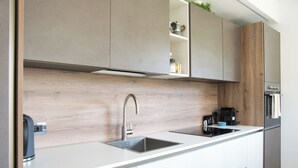 Eine moderne Küche mit Spüle, einer Kaffeemaschine und einem Edelstahl-Kühlschrank.