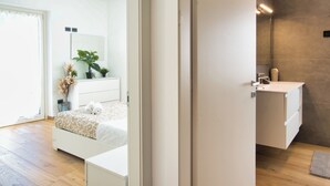 Ein modernes Schlafzimmer mit Bett, Nachttisch und einem großen Spiegel.