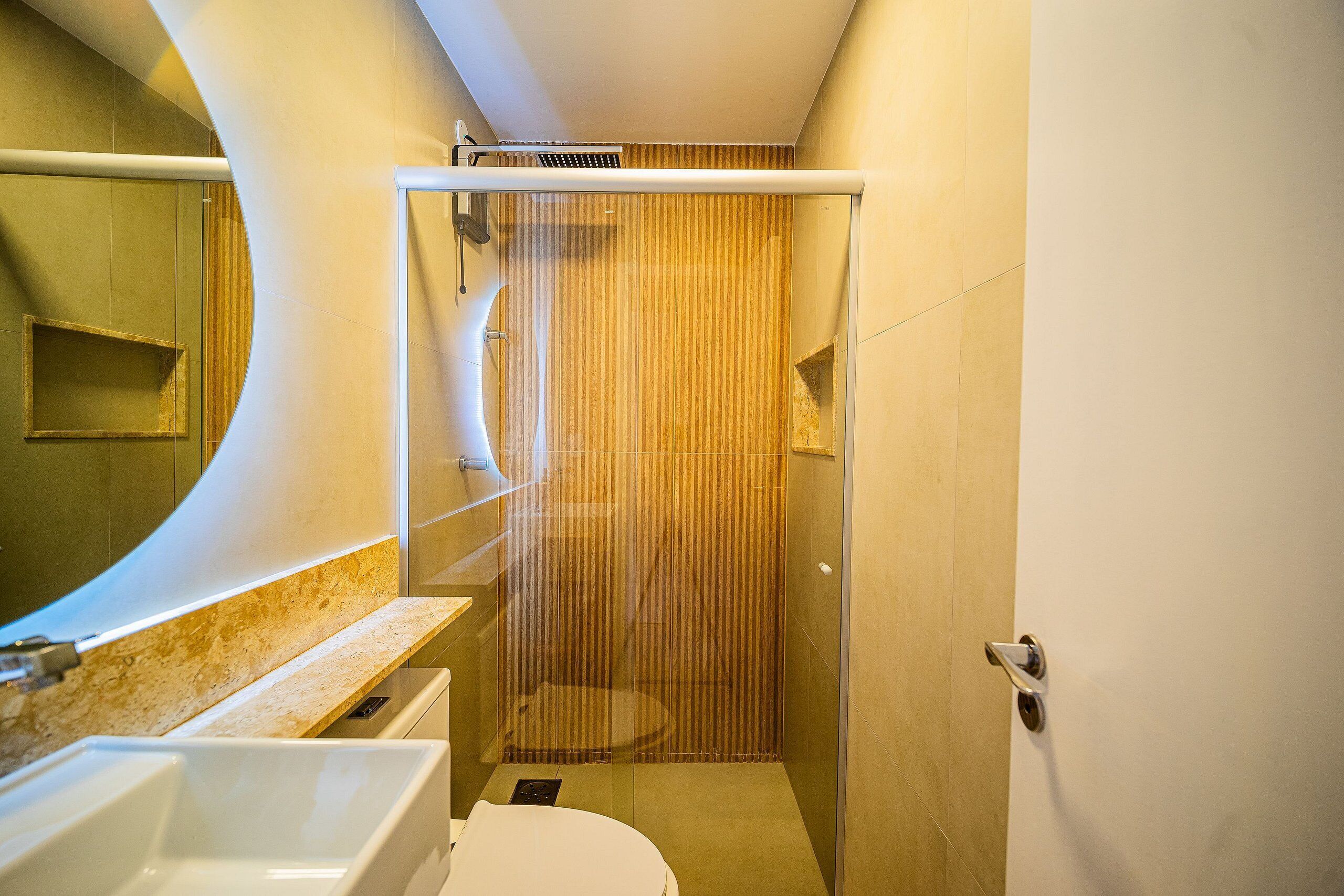 Une salle de bain moderne avec une douche à parois de verre, un lavabo et des toilettes.