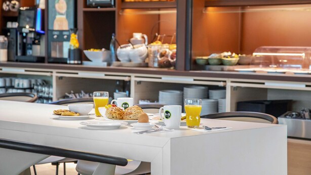 A breakfast buffet with various food items and a coffee station. - B&B Hotel Würzburg-Altstadt (Würzburg)