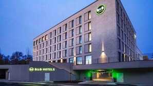 A modern B&B hotel with a brick facade, multiple windows, and a well-lit entrance. - B&B Hotel Würzburg-Altstadt (Würzburg)