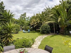A well-maintained garden with a stone pathway, lush greenery, and outdoor seating. - Guesthouse “Chambre Champêtre” with Shared Terrace, Garden, and Wi-Fi (Lannion)