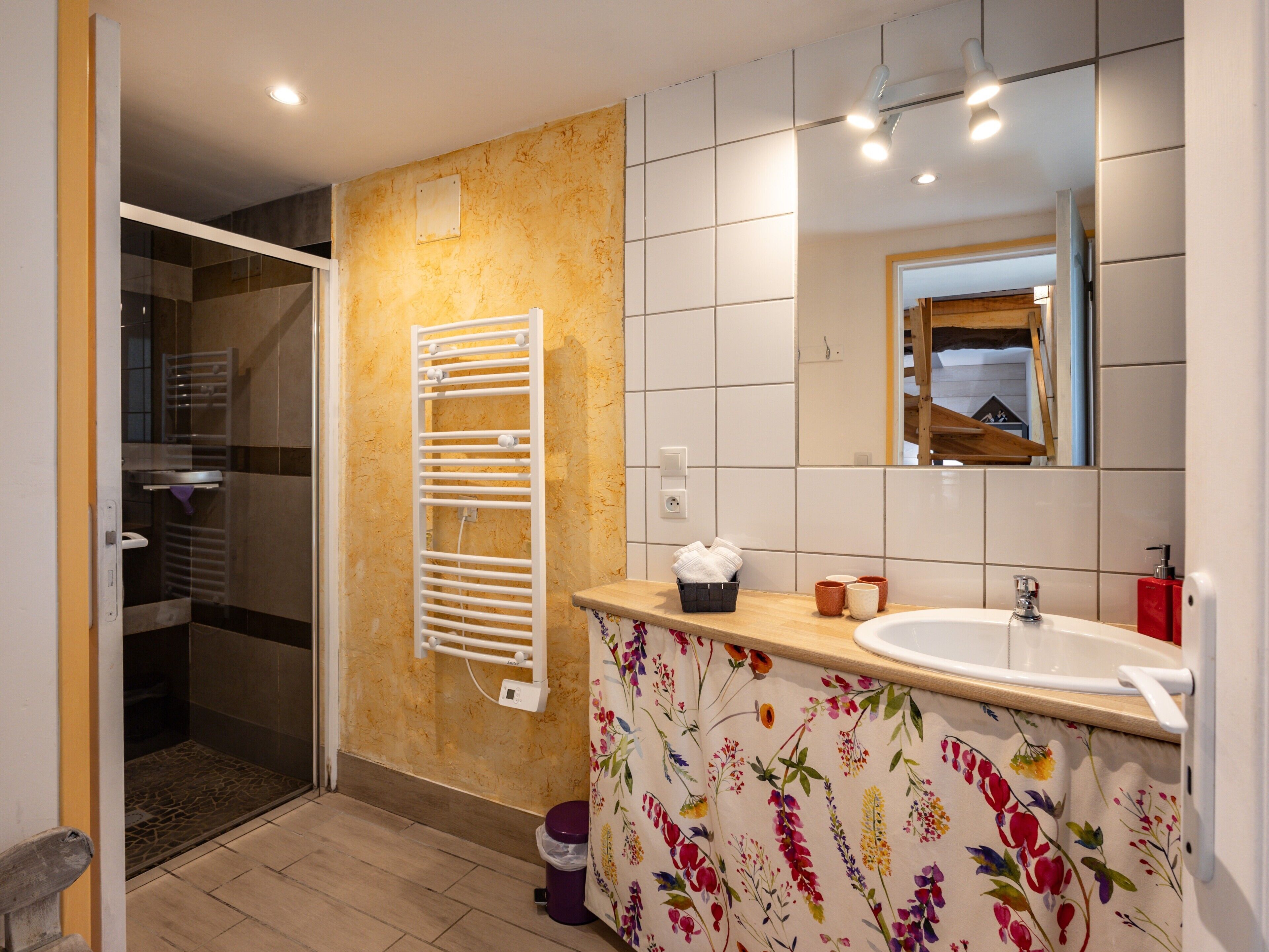 Une salle de bain équipée d’une douche, de toilettes, d’un lavabo et d’un miroir.