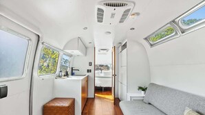 A compact, modern interior with a kitchenette, a sofa, and a small seating area.