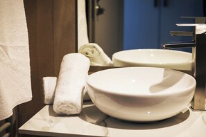 A bathroom with a white marble sink, a towel, and a mirror. - PENSIUNEA BERZASCA (Berzasca)