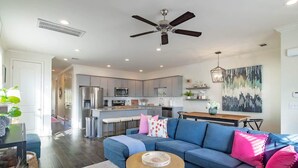 A modern living room with a sofa, coffee table, and a ceiling fan.