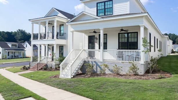 A two-story house with a front porch, a staircase, and a small garden. - The Lamar Landing (Oxford)