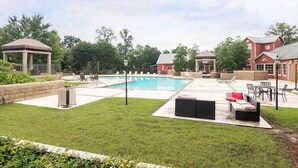 Ein Garten mit Swimmingpool, Sitzgelegenheiten im Freien und einem Gazebo.