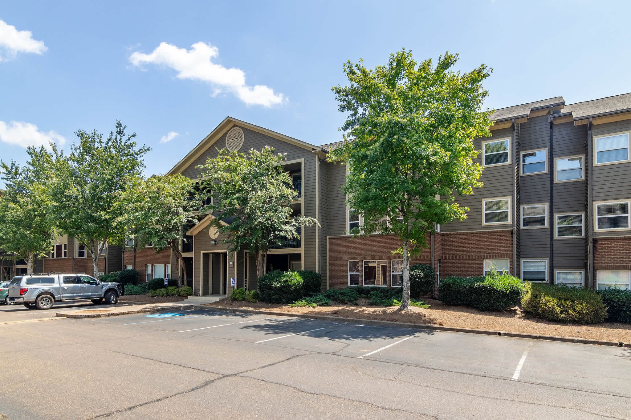 A multi-story building with a parking lot in front.