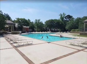 A swimming pool with lounge chairs, a gazebo, and trees in the background. - Gated Condo, Close to Ole Miss! (Oxford)