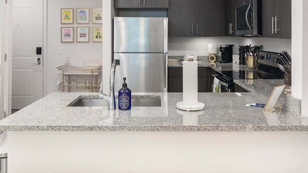 A modern kitchen with a central island, stainless steel appliances, and a bar seating area. - Welcome to the 50 YARD LINE! (Oxford)