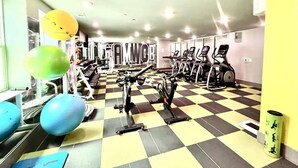 A gym with exercise equipment, a checkered floor, and a yellow wall. - Welcome to the 50 YARD LINE! (Oxford)