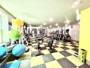 A gym with exercise equipment, a checkered floor, and a yellow wall. - Welcome to the 50 YARD LINE! (Oxford)