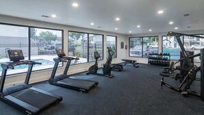 Ein Fitnessstudio mit Laufbändern, Crosstrainern und Kraftgeräten.
