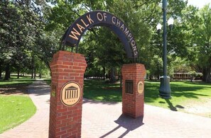 A brick archway with the inscription 'WALK OF CHAMPIONS' and a plaque with a classical building emblem. - The Haven at Old Taylor Place (Oxford)