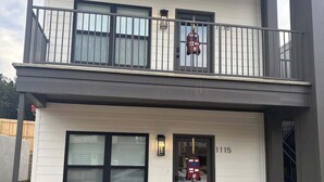 A two-story building with a balcony, a mailbox, and a door with the number 1115. - The Rebel Sole (Oxford)