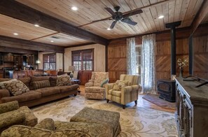 A cozy living room with a sofa, armchairs, and a fireplace.