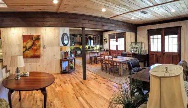 Un interior rústico con suelos de madera, comedor, cocina y sala de estar.