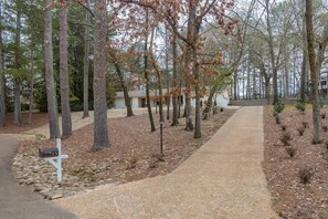 A pathway lined with trees leading to a building with a mailbox. - Colonial Cottage (Oxford)