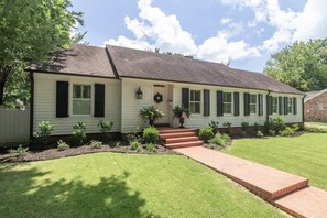 A single-story house with a front porch, a brick pathway leading to the entrance, and a well-maintained lawn. - Southern Escape – Walk to The Square and Grove (Oxford)