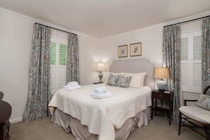 A hotel room with a bed, two bedside tables with lamps, a chair, and curtains. - Southern Escape – Walk to The Square and Grove (Oxford)