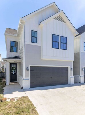 A two-story house with a garage, a front door with a wreath, and a clear sky. - Lily Loop Retreat (Oxford)