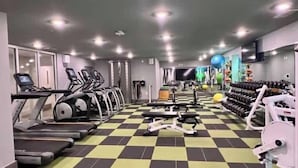 Een sportschool met loopbanden, elliptische trainers en gewichten.