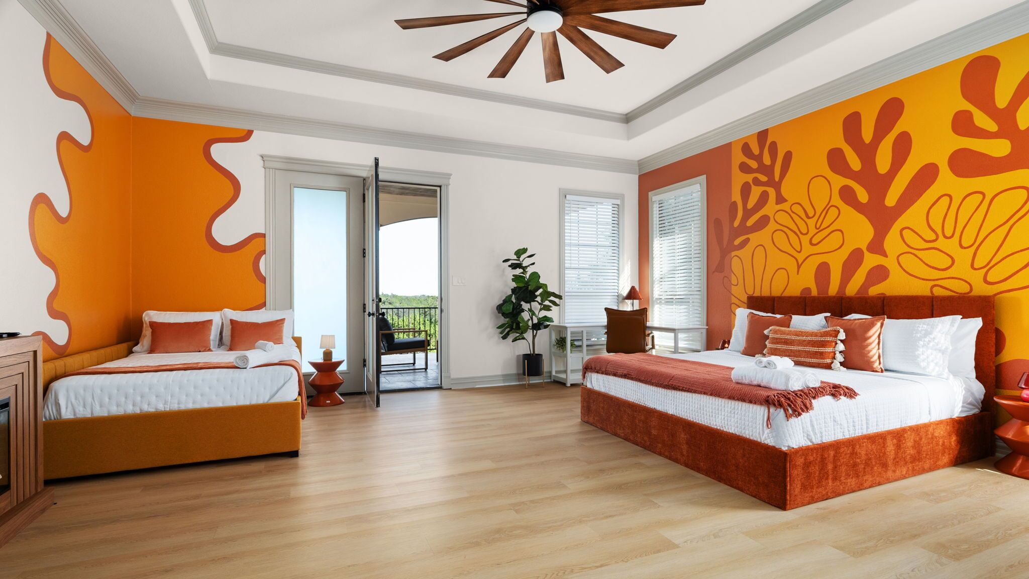 A hotel room with two beds, a balcony, and a large window.