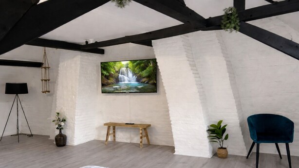 A bedroom with a bed, a bench, a TV, and a plant. - Apart'Moment EN GROUPE - La Terrasse Victor Hugo (Saint-Omer)
